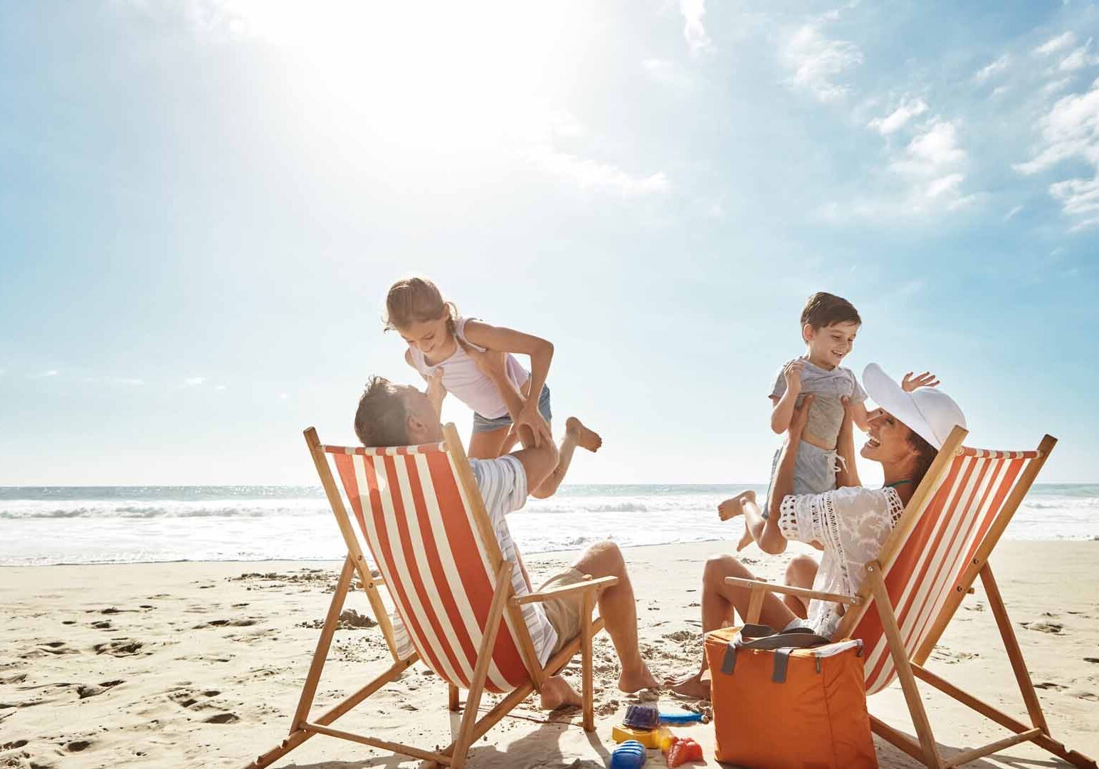 Family, beach and kids relax chair vacation adventure, bonding and play game together on tropical summer. Parents, children and excited of ocean island, energy and sunshine travel in Greece